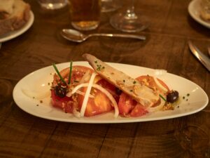Tomate rosa, con ventresca de atún, cebolla de fuentes y olivas negras del Bajo Aragón